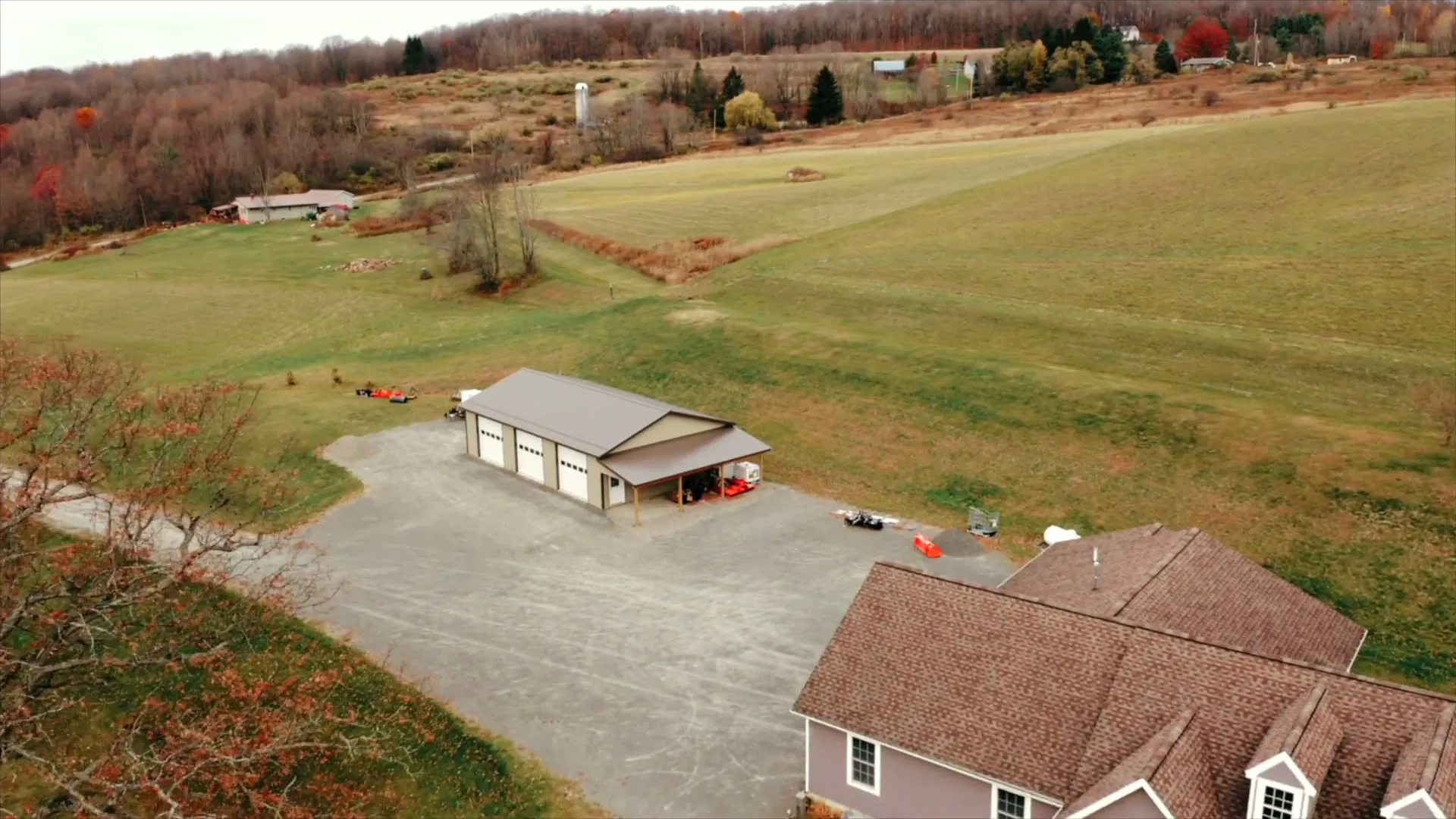 Aerial view of a Pennsylvania property with a tan post-frame garage beside a house